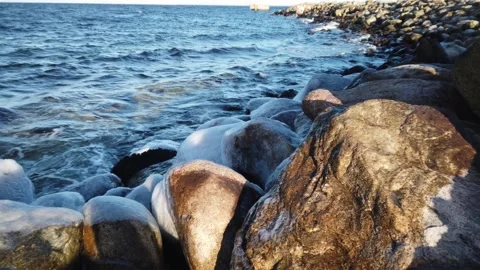 4K Pan of blue ocean and icy rocks along shore of Oresund, in Malmo, Sweden. Stockbeeldmateriaal 147190368