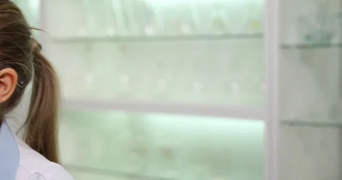 4K Pan left closeup technician woman specialist work on microscope research job Stock Footage 78772476