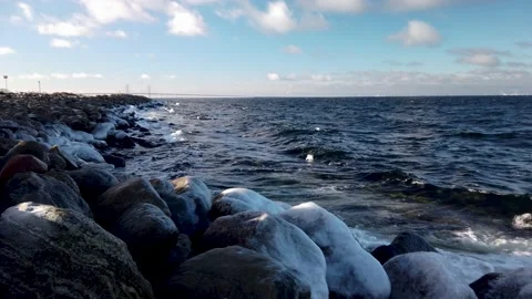 4K Pan of ocean waves and icy rocks along coast of Oresund, in Malmo, Sweden. Stockbeeldmateriaal 147189962