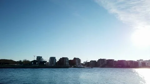 4K Pan over Oresund, Malmo, Sweden. Sun reflecting on water, buildings on coast Stock Footage