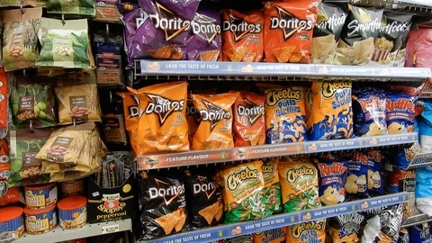 4K Pan Of Potato Chips And Other Junk Food In Aisle Video stock 89565880