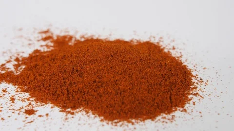 4K Pan to red chilli or cayenne powder onto white surface or background Stock Footage 88480909