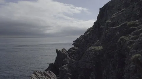 4k pan of rocky cliffs over the sea- boat floats on the ocean. Sunny day Stock Footage 56702733