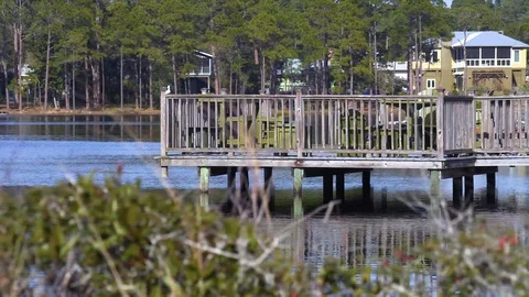 4K Pan of Secluded Dock on Quiet Lake with Plants in Foreground Video stock 109380467