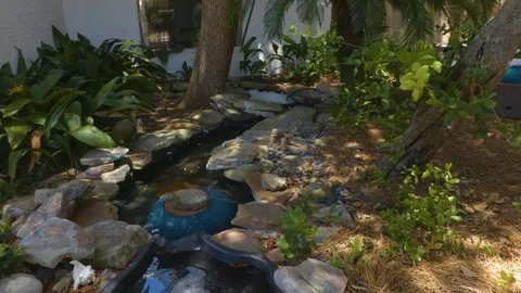 4k Pan of Serene Backyard Stream Stock Footage 107998473