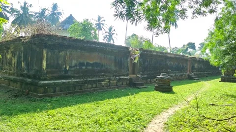 4K Pan Shot of Ancient Stone Walls and Lush Greenery at Cherapuram Shiva Te.. Stock Footage 329557129