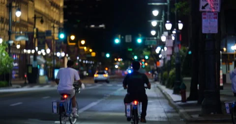 4K PAN OF YOUNG MEN ON BIKES RIDING DOWN ABANDONED CITY STREET Stock Footage 132602956