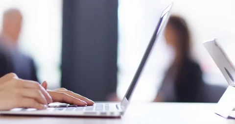 4K Panning shot with focus pull from hands typing on laptop to businesswoman Stock Footage 104578066