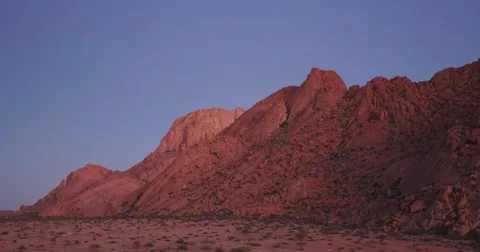 4K panning shot of the moon setting over granite peaks of the Spitzkoppe Stock Footage 64698090