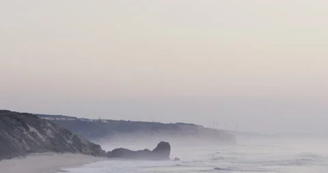 4K panning shot of ocean waves breaking on sandy beach of Portuguese coast Stock Footage 163084956