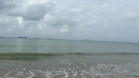 4K Panning Shot of Ocean Waves, Coastal Pier and Distant Cargo Ships Stock Footage 330918115