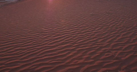4K panning shot of sand dunes of the sun setting in the background Stock Footage 64696901