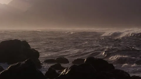 4K: Panning Of Waves Crashing into Rocks in Golden Light on Ocean Stock Footage 68576376