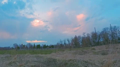 4k panoramic sunset time-lapse in a field in cloudy weather, visible church Stock Footage 107303504