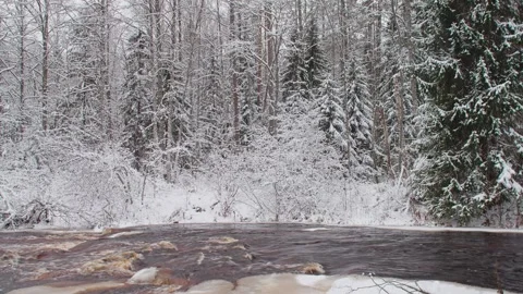 4k, A panoramic view of the brown Roshchinka River, partially covered with ice Video stock 326551557