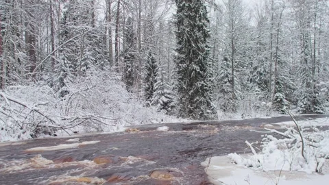 4k, A panoramic view of the brown Roshchinka River, partially covered with ice Video stock 326552927