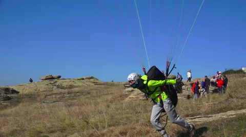 4k paraglider takes off mountain during paragliding extreme sport competition Stock-Footage 44179799