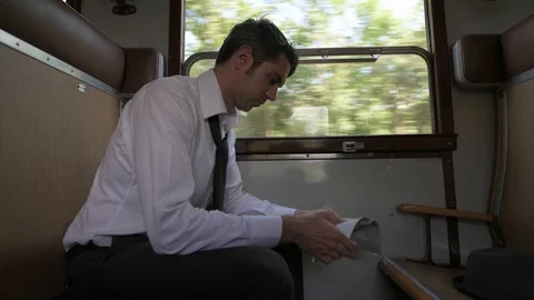 4K passenger making himself comfortable in train car checking his map Stock Footage 90813030