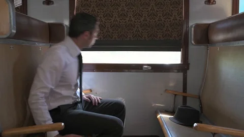 4K passenger in old vintage train lifting the drapes to look outside the window Video stock 90806423
