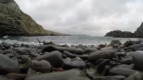 4K Pebble eye view of waves coming onto the rocky beach Stock Footage 45623937
