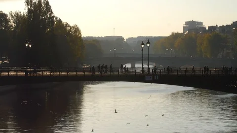 4K PEDESTRIANS CROSS BRIDGE OVER SEINE RIVER IN PARIS Stock Footage 97520522