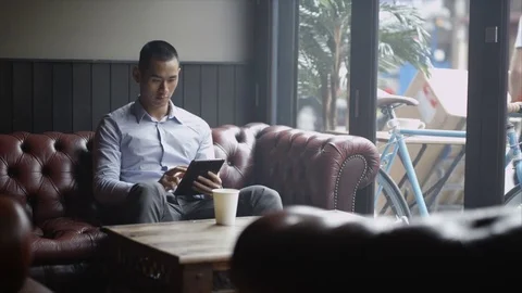4K Pensive Young Man Sitting Alone In Cafe Looking At Computer Tablet Video stock 75668297