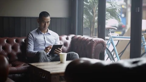 4K Pensive Young Man Sitting Alone In Cafe Looking At Computer Tablet Stock Footage 75669051