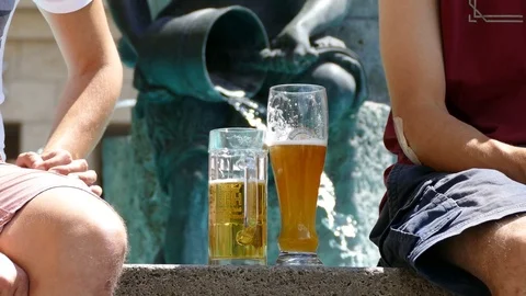 4K People enjoy drinking beer at the fountain in the hot sun Stock Footage