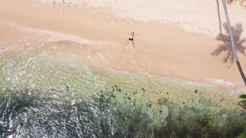 4K person lying stretched out on exotic sunny beach making star shape Stock Footage 201754640