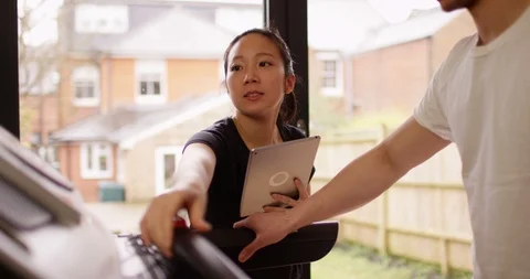 4K Personal trainer adjusting treadmill settings for her client at the gym Stock Footage 86809781