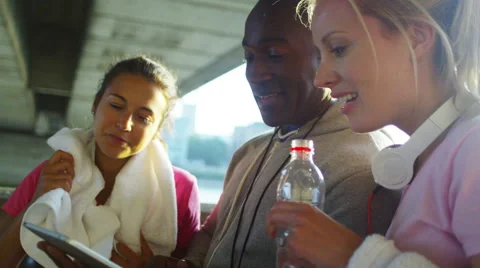 4K Personal trainer with computer tablet working with female clients outdoors in Stock Footage 66471417