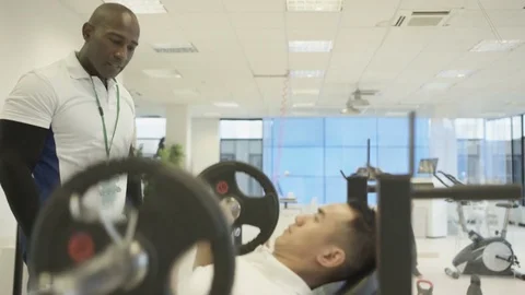4K Personal trainer watching over clients, working out in modern gym Video stock 75846913