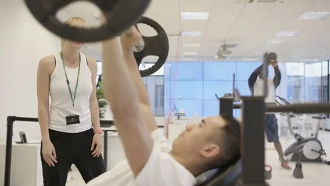 4K Personal trainer watching over clients, working out in modern gym Stock Footage 75851256