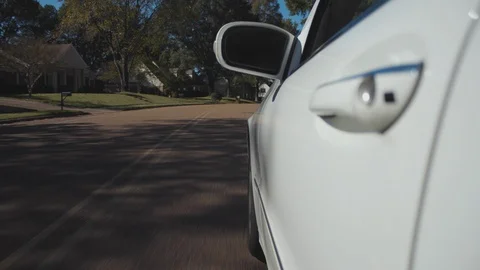 4K perspective shot driving in suburban neighborhood in white car Stock Footage