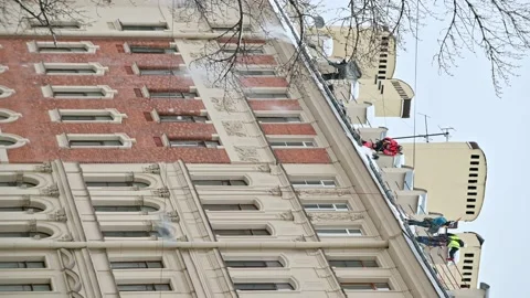 4K portrait 16:9. Workmen from maintenance company clean living building rooftop Stock Footage 168437811