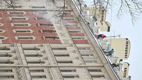 4K portrait 16:9. Workmen from maintenance company clean living building rooftop Stock Footage 168437954