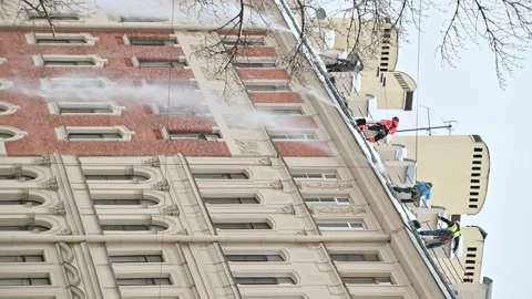 4K portrait 16:9. Workmen from maintenance company clean building rooftop Stock Footage 168437972