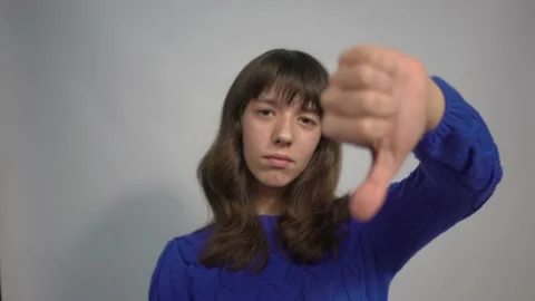 4k Portrait of attractive grumpy brown haired girl showing thumb down Stock Footage 198932613