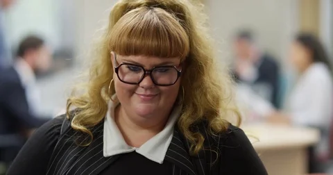 4K Portrait attractive plus size businesswoman giving a friendly smile to camera Stock Footage 76240882
