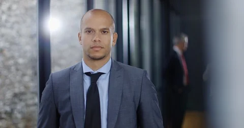 4K Portrait of businessman looking at camera with colleagues in background Stock Footage 101409634