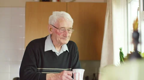 4K Portrait of elderly man alone, having a hot drink in his kitchen.  Stock Footage 55939315