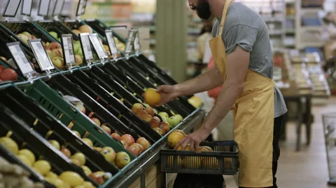 4K Portrait friendly worker in grocery store turns to smile at camera Stock Footage 64889710