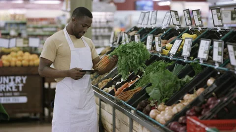4K Portrait friendly worker in grocery store turns to smile at camera Stock Footage 64901666