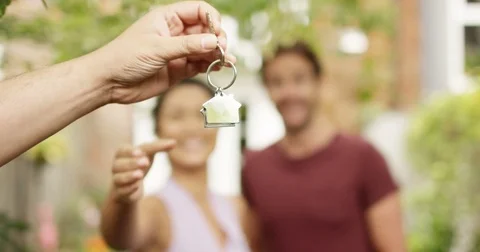 4K Portrait happy couple in front of new home, taking the key from estate agent Stock Footage 80474947