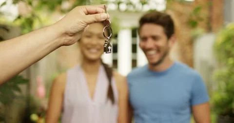 4K Portrait happy couple in front of new home, taking the key from estate agent Stock Footage 80578326