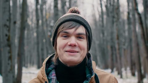 4K Portrait of a happy man in a stylish winter dress. Smiles charmingly. The sun Видео 98009834