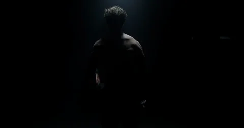 4K Portrait Of Man Lifting Weights Away From Camera Under Spotlight Preparing Stock Footage 113767171