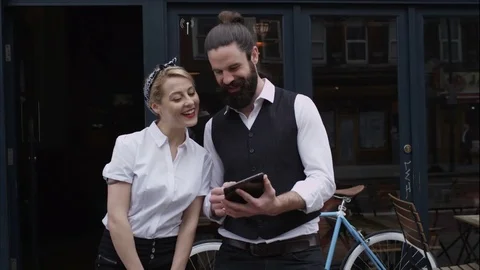 4K Portrait Smiling Cafe Owners Standing Outside Shop With Computer Tablet Stock Footage 75700367