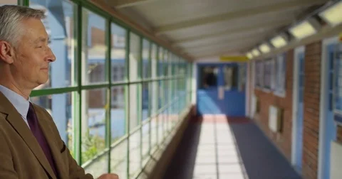 4K Portrait smiling friendly teacher standing in school hallway on a sunny day.  Stock Footage 76960919