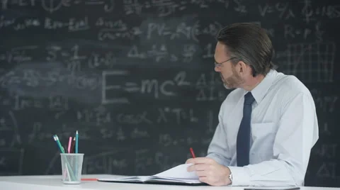 4K Portrait smiling man in classroom studying math formulas on blackboard Stock Footage 67879269